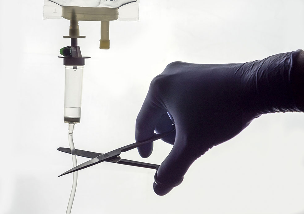 Médico corta com tesoura medicação para doente, conceito de eutanásia